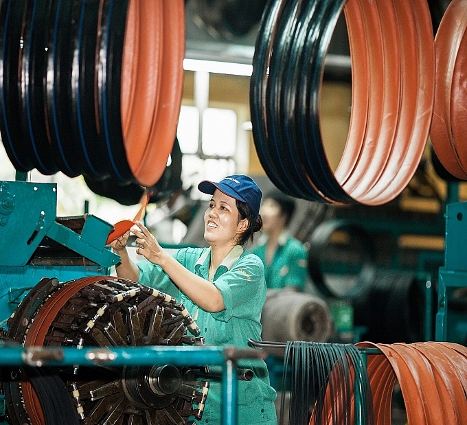 Niềm vui của nữ công nhân ở xưởng thành hình lốp xe đạp Xí nghiệp Săm lốp xe đạp xe máy, Công ty CP Cao su Đà Nẵng. Ảnh: NGUYỄN VĂN TÍNH.