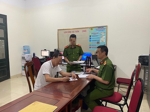 Tài xế Hoàng Nọc Vĩnh (áo trắng) tại cơ công an.